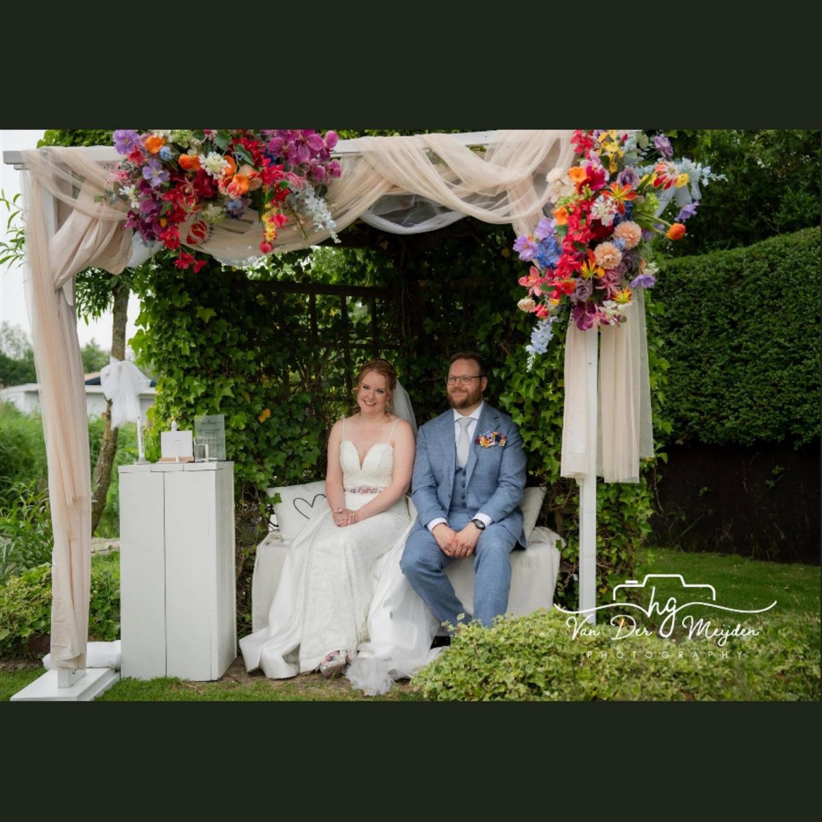 Bruidsboog met kleurrijke kunstbloemen — te huur voor jullie trouwdag